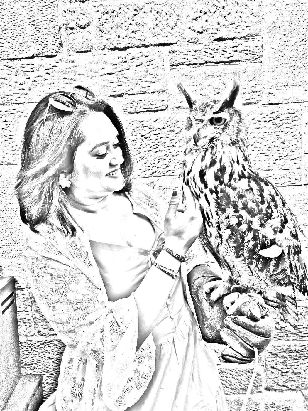 Bhagyashri smiling at an eagle owl perched on a falconer's glove